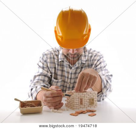 Hombre adulto construir una casa de ladrillo aislada en blanco - una serie de imágenes de la construcción de una casa.