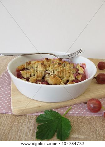 Homemade gooseberry crumble - Gooseberries topped with crumble from of butter, flour, rolled oats and sugar