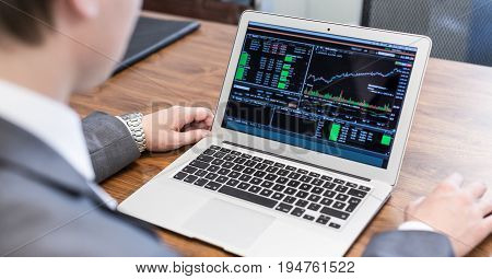 Corporate businessman analyzing economic data on laptop computer. Man's hands on notebook computer, business person at workplace.