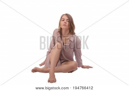 Saxy woman with blonde hair wearing in shirt sitting on the ground. isolated on white background.