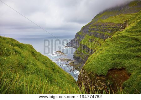 Dramatic landscape on a cloudy day at Faroe Islands, Danmark. Rainy day in july.