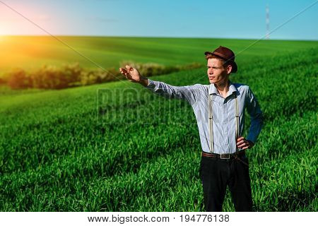 Man On The Field Shows On Elongated Hand Somewhere Far Into Something