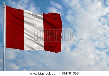 National flag of Peru on a flagpole in front of blue sky.