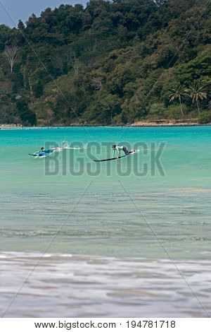 10/06/2017 Pantau Mawun Lombok Indonesia. Young couple learns to surf on a long board on learner waves in a paradise location.
