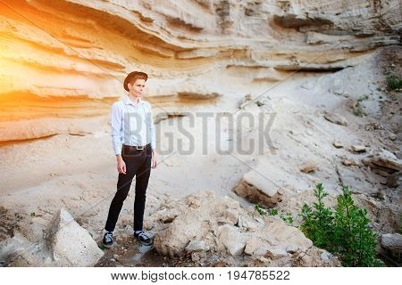An Attractive Man Is Standing In The Middle Of A Sand Quarry And Looking Thoughtfully In The Distanc