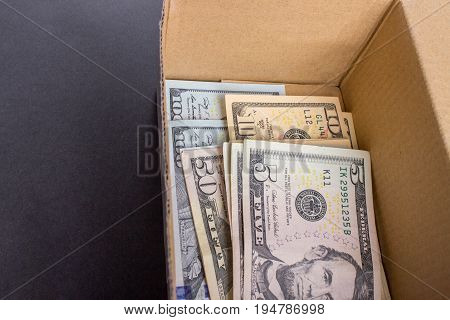 A pile of dollar bills lying in a box.