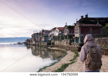 tourist walking along the seashore in the town of Combarro, Pontevedra, Galicia, Spain