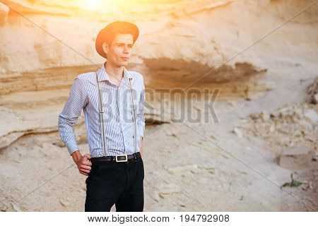 Stylish Attractive Man Stands In The Middle Of A Sand Quarry And Poses On The Camera