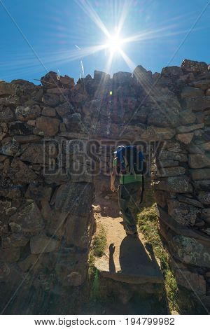 Tourist Exploring The Ancient Mysterious Inca Labyrinth-like Settlement, Called Chinkana, On The Isl