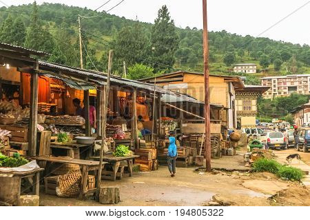 Punakha Bhutan - September 10 2016: Local Bhutanese marketplace in Punakha Bhutan. Child waiting near crates.