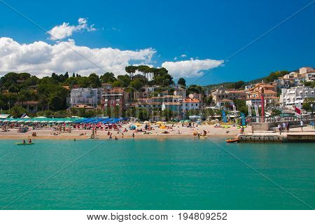 NUMANA, ITALY - JULY 1, 2017: People on the Numana beach and the city in the Marche region, adriatic sea