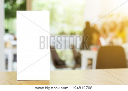Mock up blank template menu frame on wood table in restaurant with blurred background Clipping path included