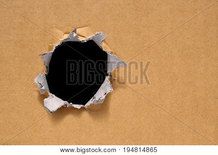 Big hole on a thick new brown cardboard. Big black hole for text copy or every design.