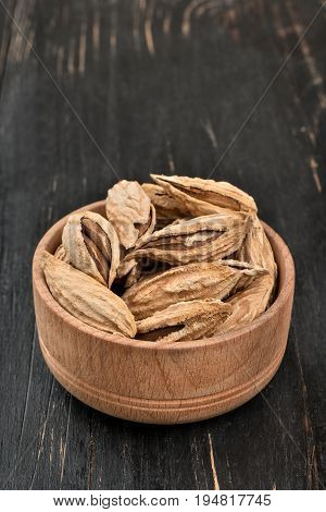 Wild uzbek inshell almonds in a bowl on wooden background