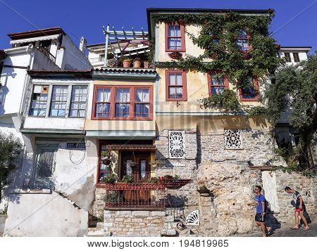 KAVALA GREECE - JULY 6 2017: Tourists pass along colorful houses in Kavala old town.