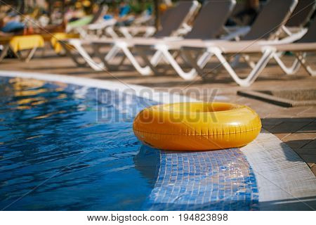floating ring on blue water swimpool with waves reflecting in the summer sun