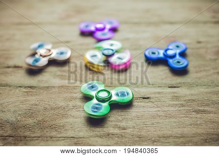 Colored Fidget Spinners Stress Relieving Toy On Wooden Background