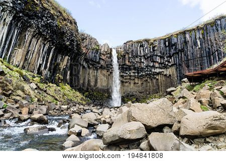 It is surrounded by dark lava columns which gave rise to its name