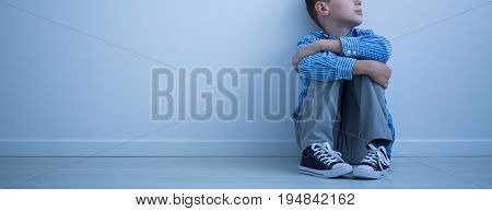 Child sitting on the floor in an empty room