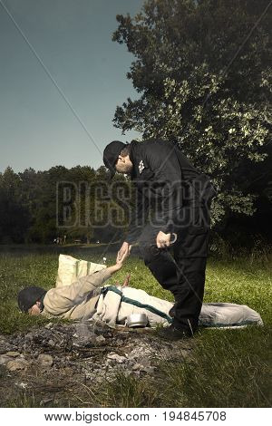 Vagabond young man sleeping in park catched by police patrol