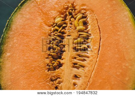 Melon seeds background and texture. Close up view of melon cut in a half with seeds. Organic texture and background. Fresh fruit. Macro view of melon surface. Melon texture. Healthy food.