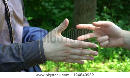 Rock scissors paper is played by two young man in the forest high definition video. slow motion