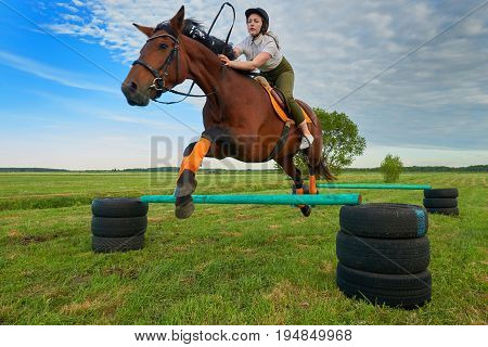 Pretty young girl jockey and her horse jumper