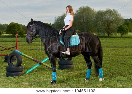 Pretty young girl riding a horse across country
