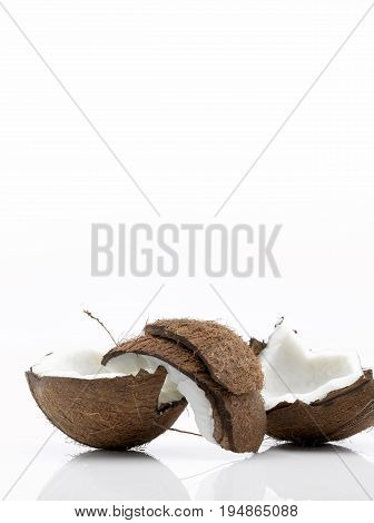 A Coconut cut in Three Pieces on a White Background