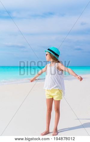 Cute little girl in hat at beach during caribbean vacation