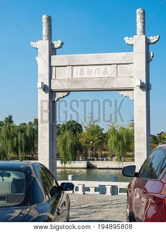 Suzhou, China - Nov 5, 2016: Stone gate in classical Chinese design named Wumen Impression (Chinese characters) on a public park, along the Waicheng River.