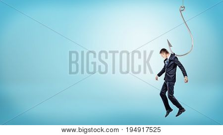 A tiny businessman hanging from a giant silver fishing hook like a puppet doll. Tight business rules. Unfree market. Corporate regulations.