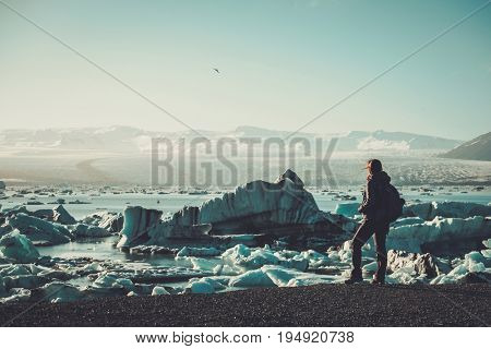 Woman explorer lookig at Jokulsarlon lagoon, Iceland.