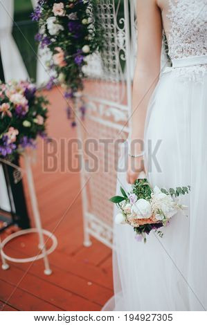 Stylish beautiful bride holds a wedding bouquet in hands