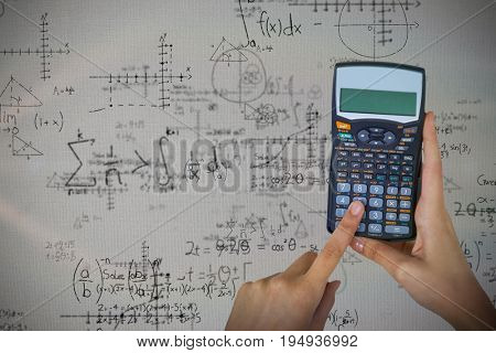 Hands of businesswoman using calculator against quadratic equations with solution