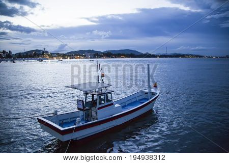 Fishing boat in the bay. While there is a thunderstorm.
