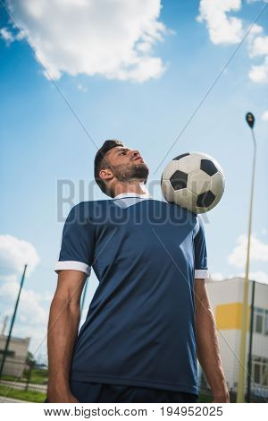 Low Angle View Of Soccer Player Training With Ball On Soccer Pitch