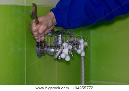 Man unscrew the mixer in the bathroom