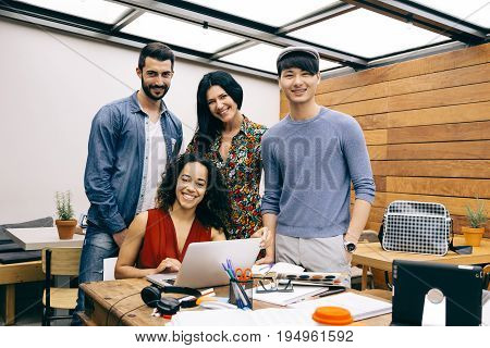 Startup of four multiethnic happy people in a modern coworking espace