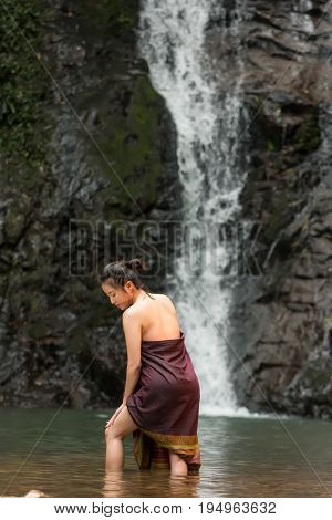 Daily life of rural women in AsiaWas bathing in a waterfall
