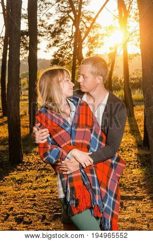 young loving couple standing hugging in the woods