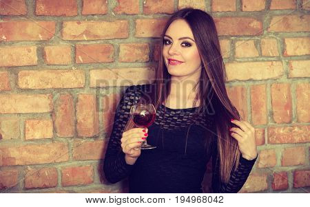 Woman Tasting Wine In Rural Cottage Interior