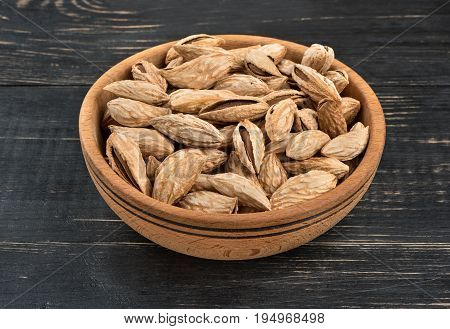 Uzbek inshell almonds in a bowl on wooden background
