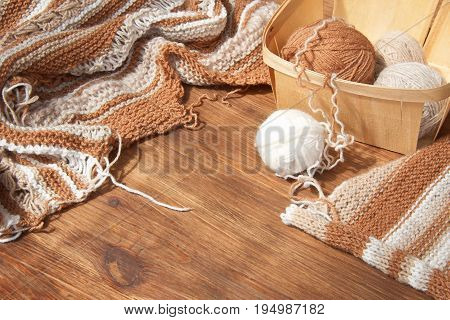 Balls of wool and knitting on the wooden background