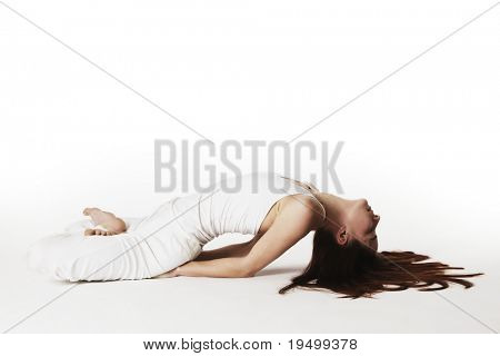 Ung dame praktiserer yoga i lotus fisk kropsholdning (Matsyasana) i hvide klæder med rødt hår spredt 