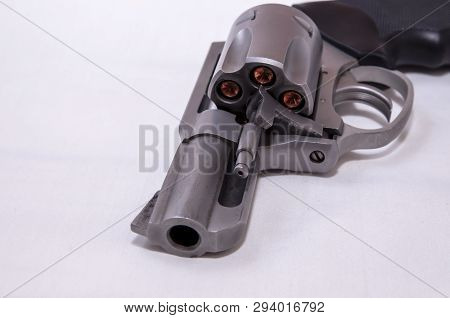 A Stainless Steel Snub Nosed 357 Magnum Revolver Loaded With Hollow Point Bullets On A White Backgro