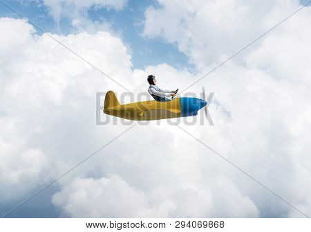 Happy Pilot Driving Small Propeller Plane On Background Of Blue Sky With Clouds. Traveling Around Th
