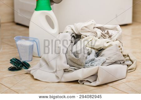 Washing Powder Detergent And Measuring Cup Next To Machine In Bathroom. Household Duties, Clothes La