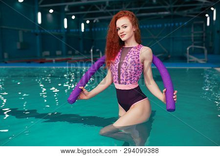 A Beautiful Young Red-haired Girl In A Fashionable Swimsuit In The Style Of The 80s Stands With A No