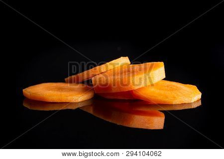 Group Of Five Slices Of Fresh Orange Carrot Isolated On Black Glass